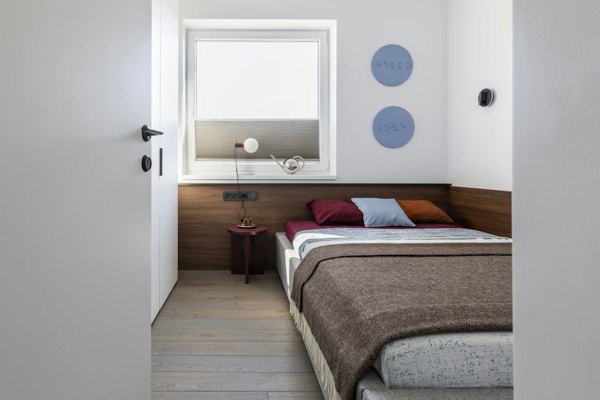 A small bedroom with a bed, wardrobe and window